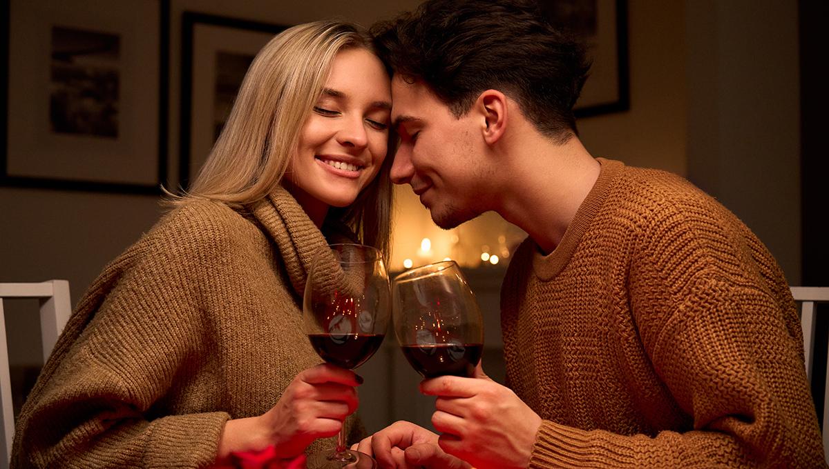 Article Cards Featured Image Happy couple in love clinking glasses drinking red wine having romantic dinner.